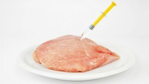 Slab of meat with a hypodermic needle stuck in it