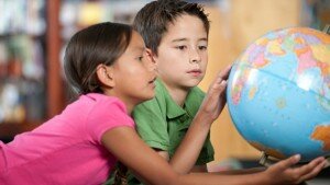 Two children looking at a globe