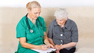 Nurse and senior woman looking at forms together