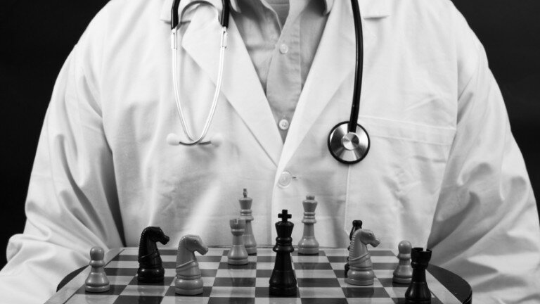 Doctor sitting in front of a chess board