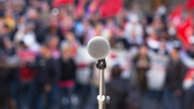 A microphone on stage in front of a crowd