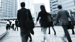 Business men and women walk along a city street